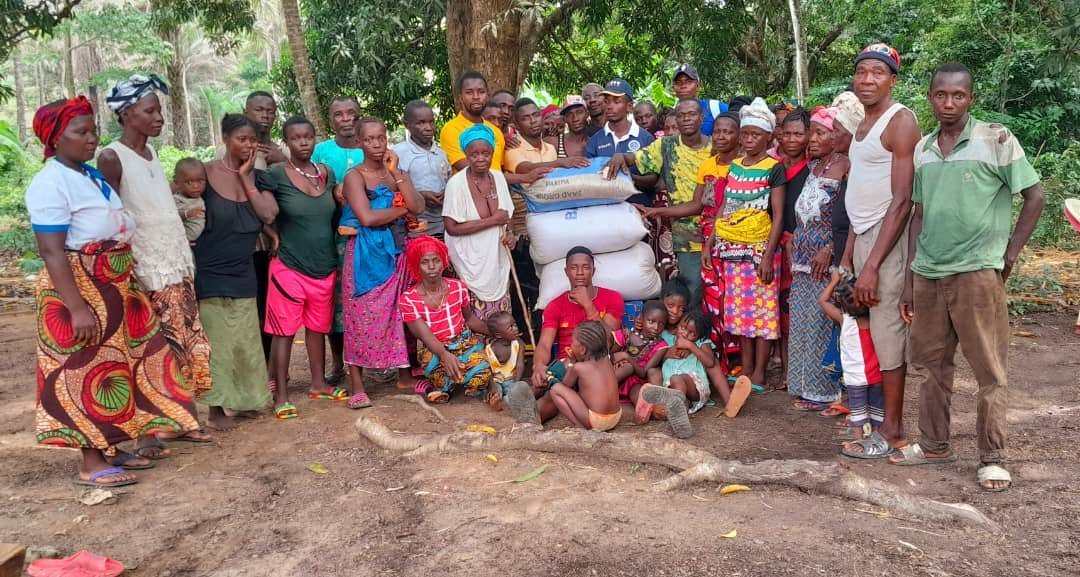 Community members gathered with bags of seedlings for the agricultural project