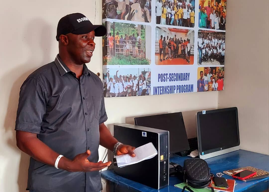 A speaker addressing students in a room with computers